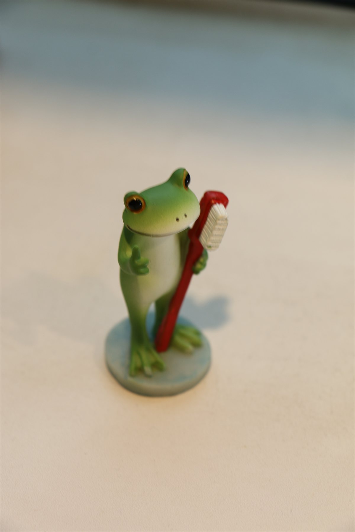 歯ブラシを持ったカエルの置物