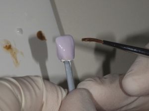 紫色のイーマックス冠に艶出し処理を施している様子